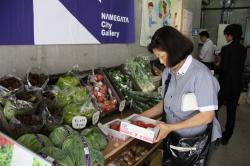 店内で野菜を手に取る来店者