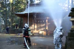 神社拝殿に向けての放水作業